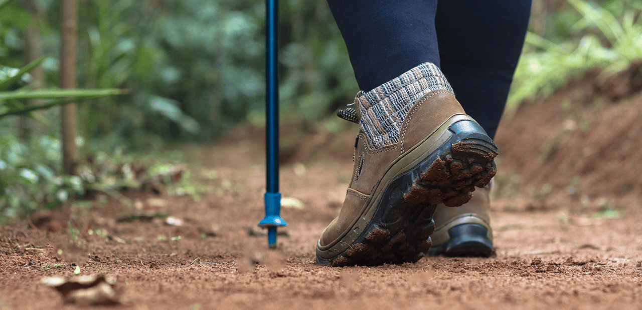 Mulher caminhando numa trilha de terra